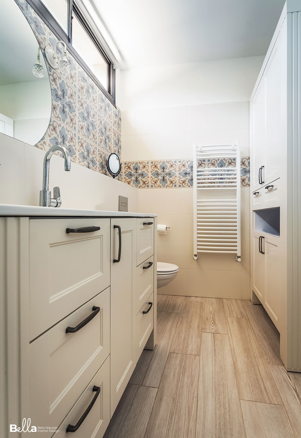 חדר שירותים עם ריצוף דמוי עץ וארון כפרי בצבע שמנת. חיפוי קירות אוריינטלי